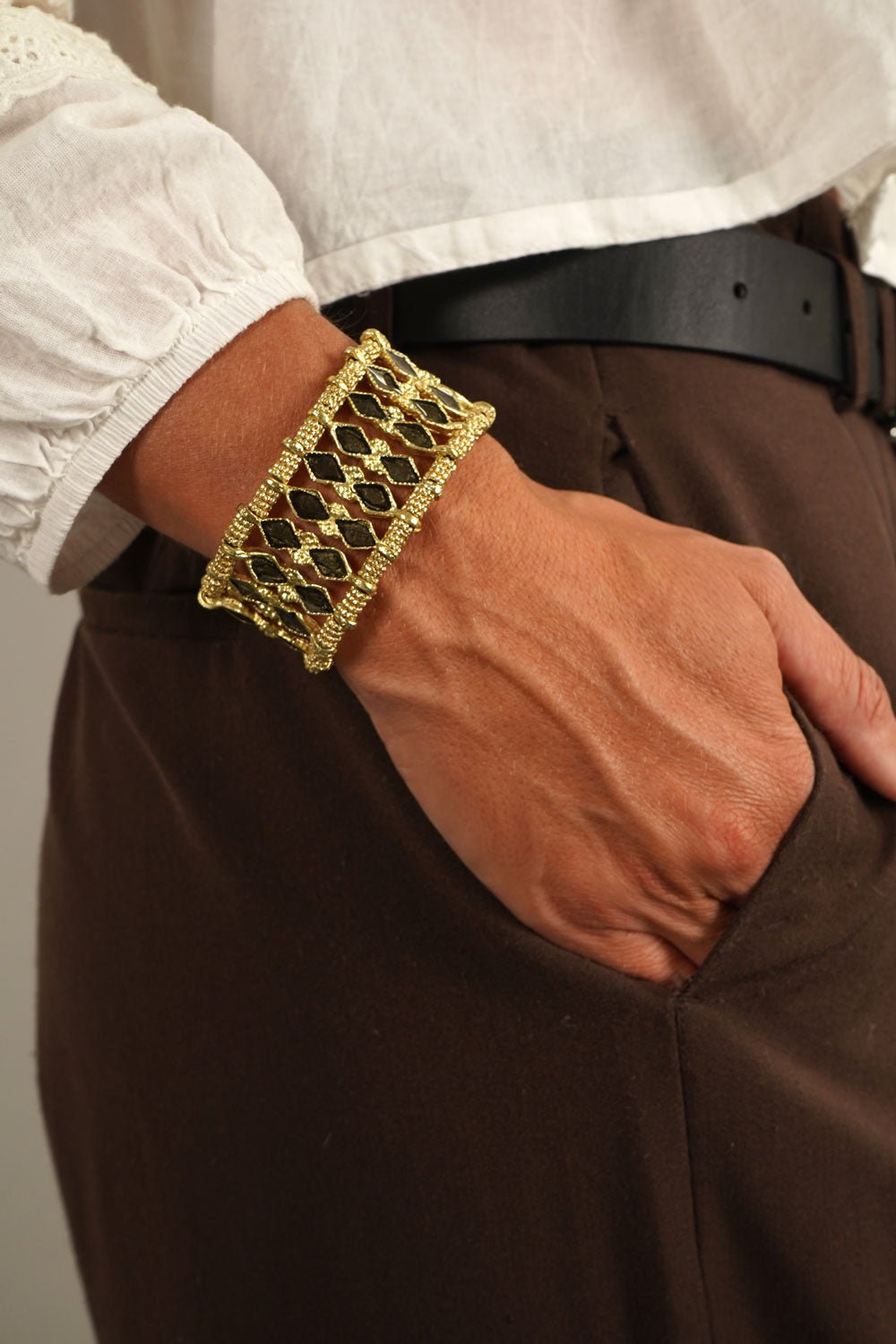 Detalle Puesto Mano Brazalete Dorado Con Diseño De Rombos Negros Cristina Oria