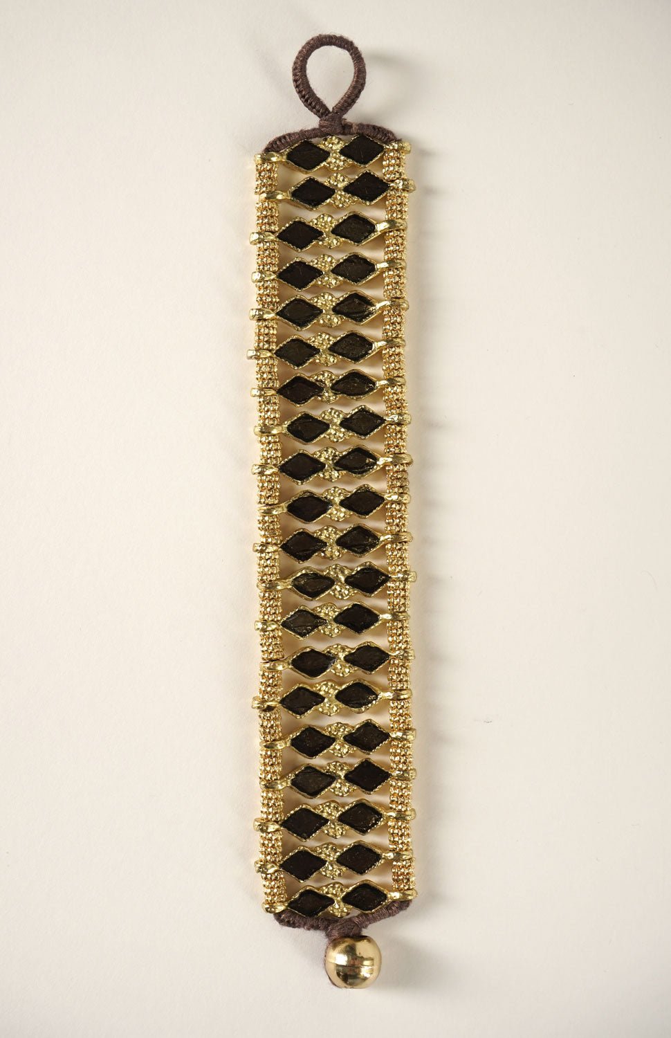 Detalle Brazalete Dorado Con Diseño De Rombos Negros Cristina Oria