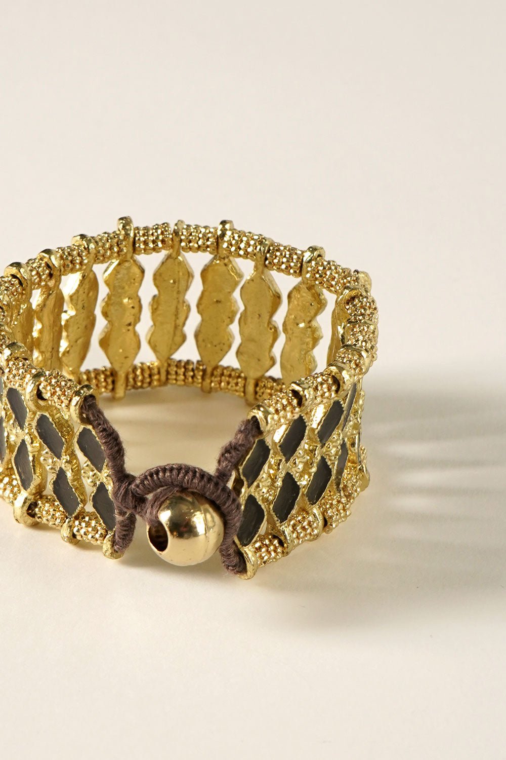 Detalle Cierre Brazalete Dorado Con Diseño De Rombos Negros Cristina Oria