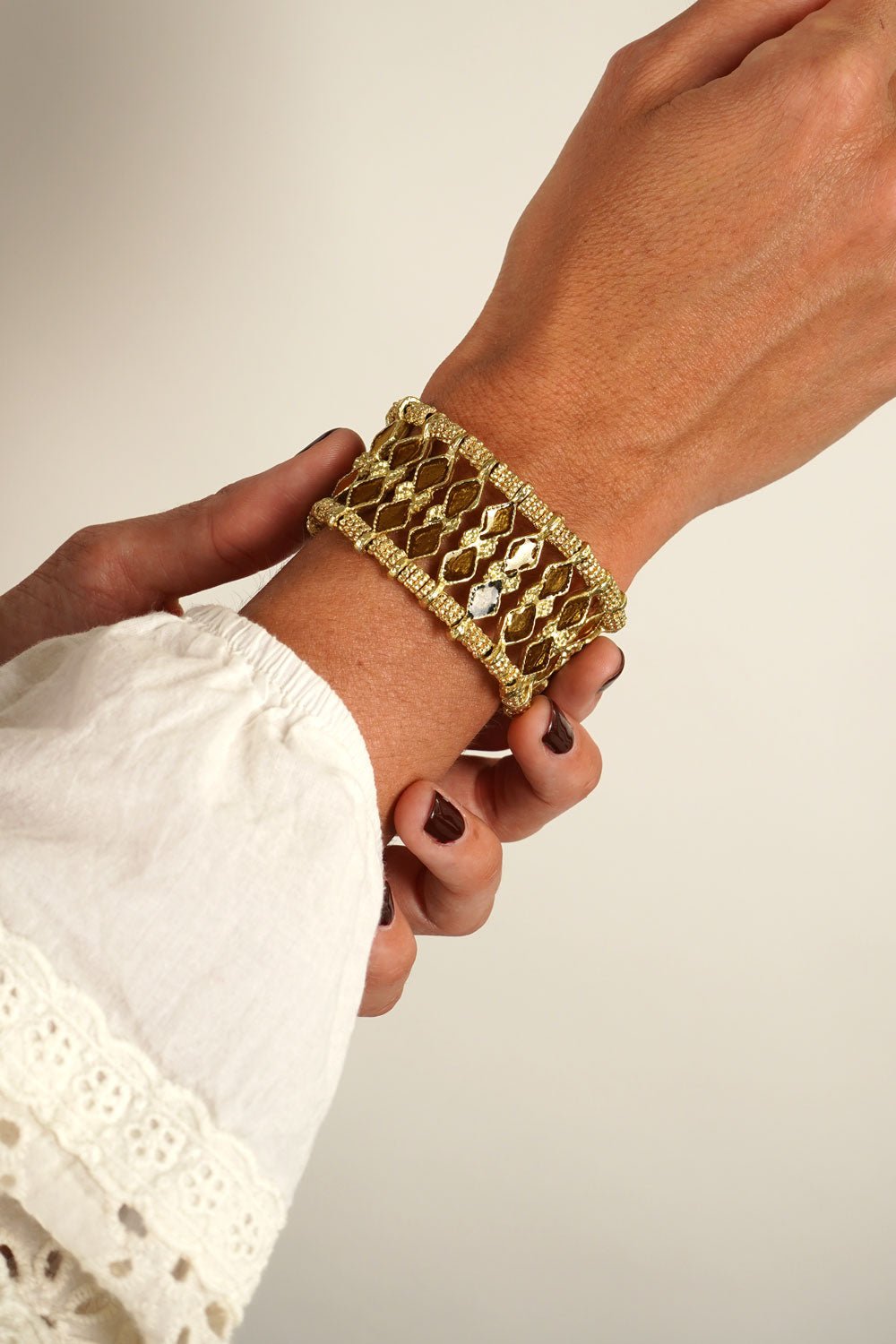 Detalle Puesto Brazalete Dorado Con Diseño De Rombos Naranjas Cristina Oria