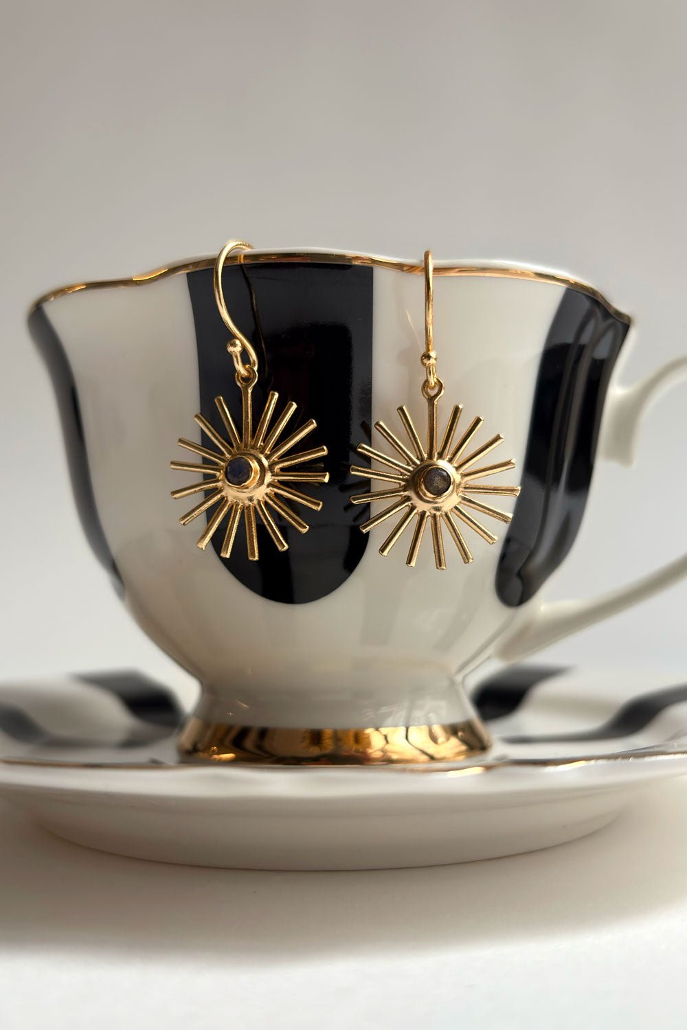 Detalle Dos Pendientes Dorados Con Diseño De Soles Y Labradoritas Grisáceas Cristina Oria