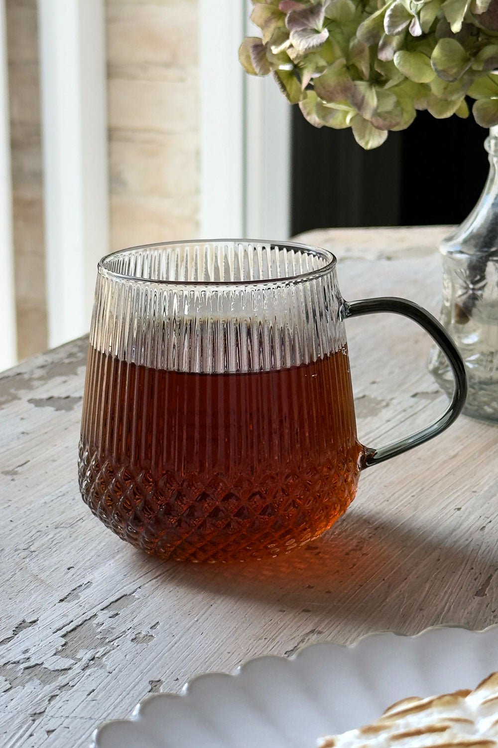 Detalle Vaso Lleno De Cristal Con Detalles Tallados Y Asa De Color Negra Cristina Oria 