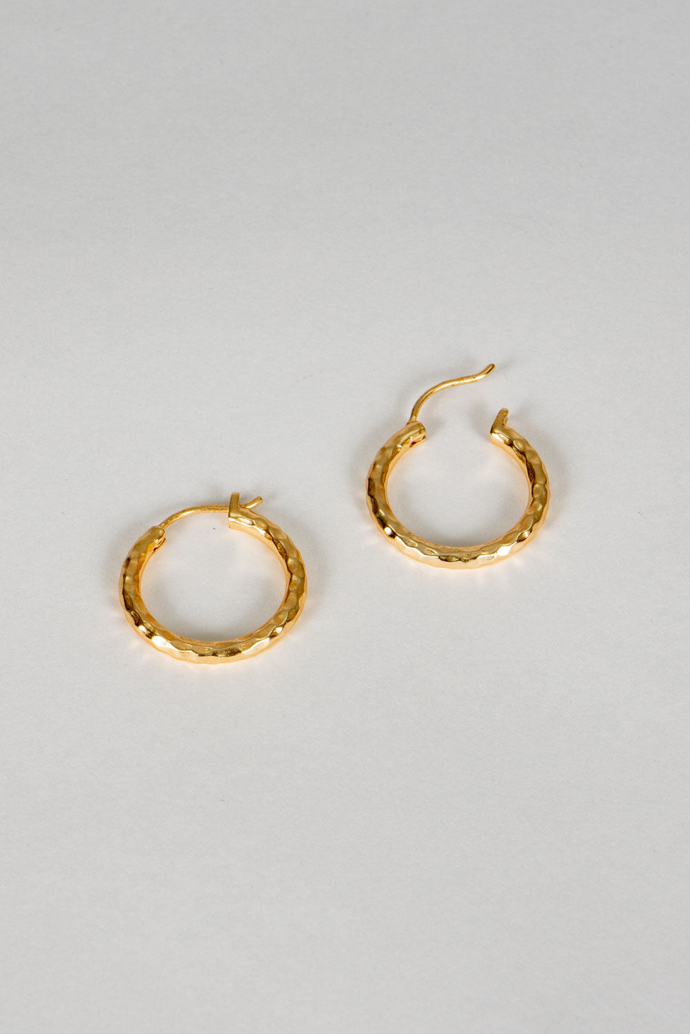 Brincos dourados com design de argolas marteladas