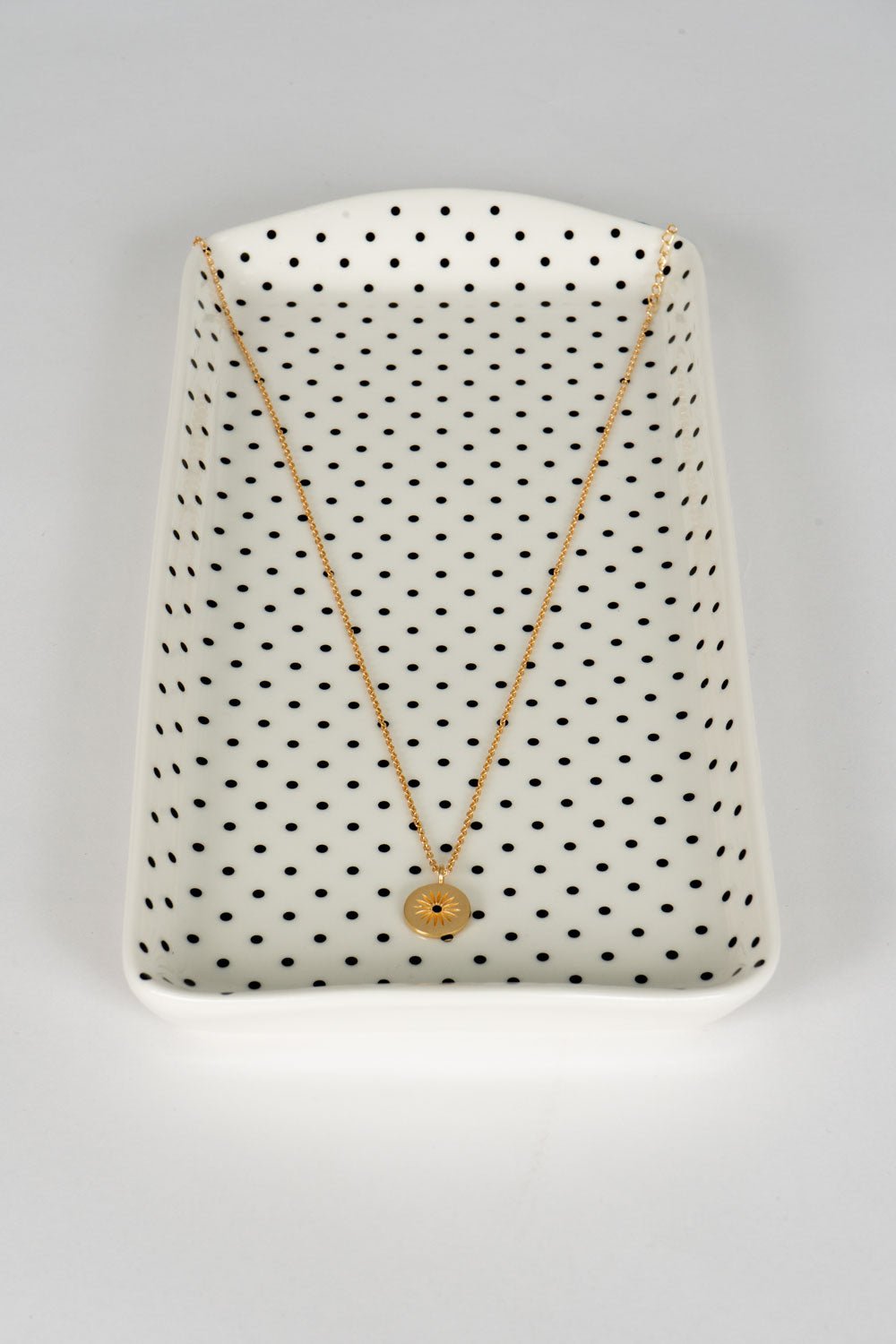 Colar dourado com pendente redondo de sol e zircónia negra