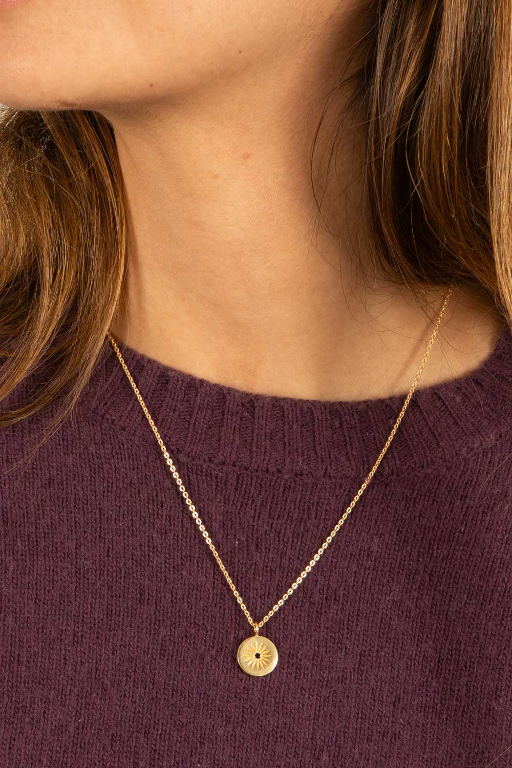 Colar dourado com pendente redondo de sol e zircónia negra