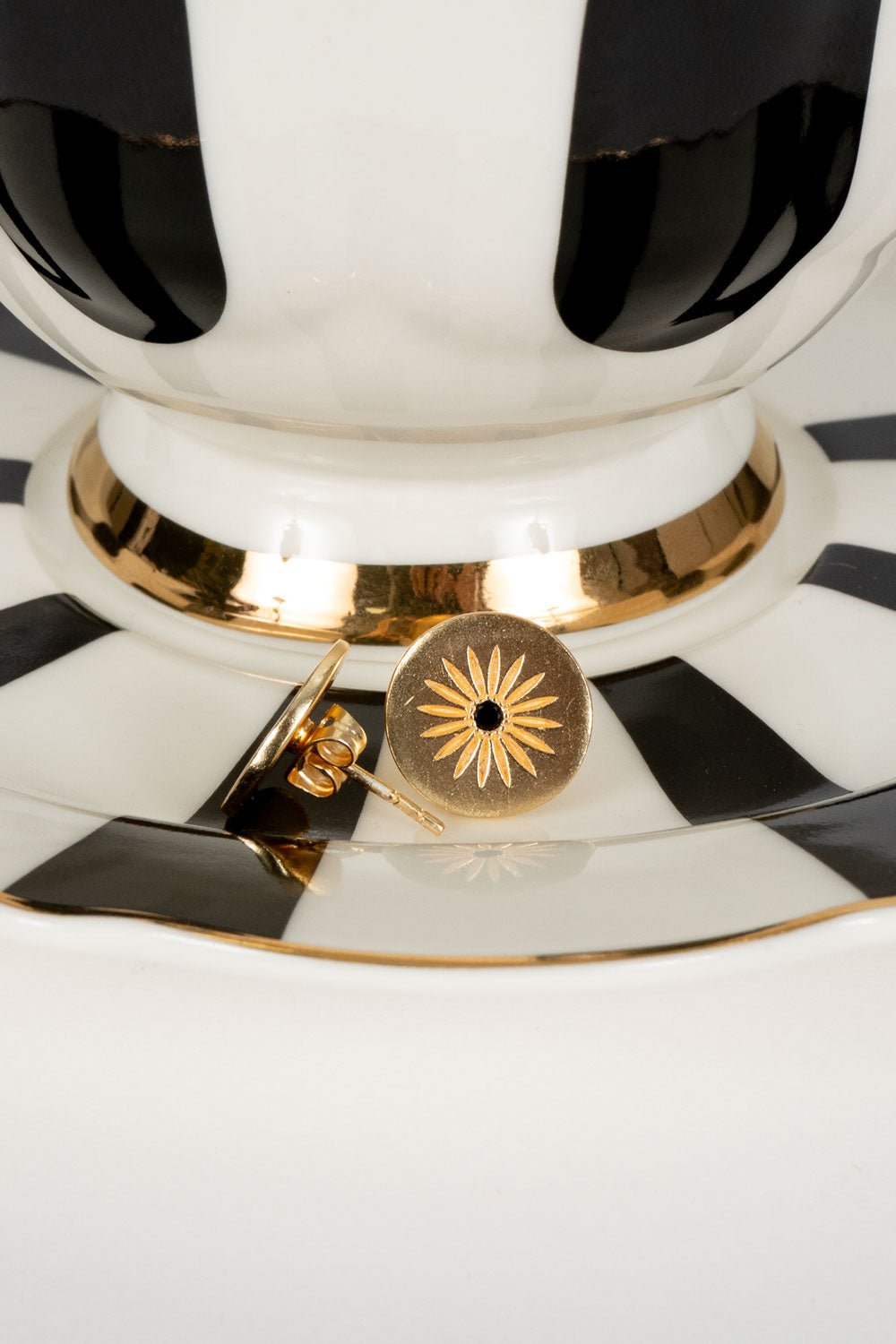 Brincos dourados redondos com design de sol e zircónia negra