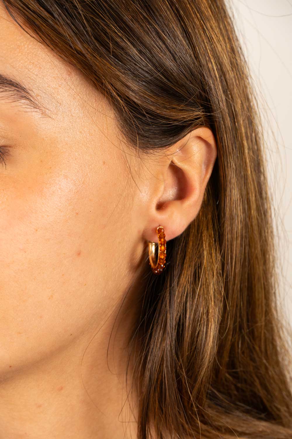 Brincos dourados com design de argolas e pedras âmbar