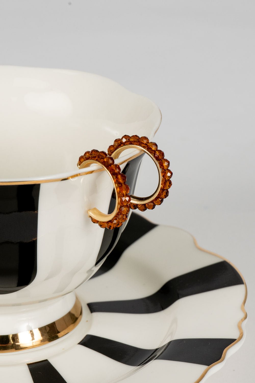 Brincos dourados com design de argolas e pedras âmbar