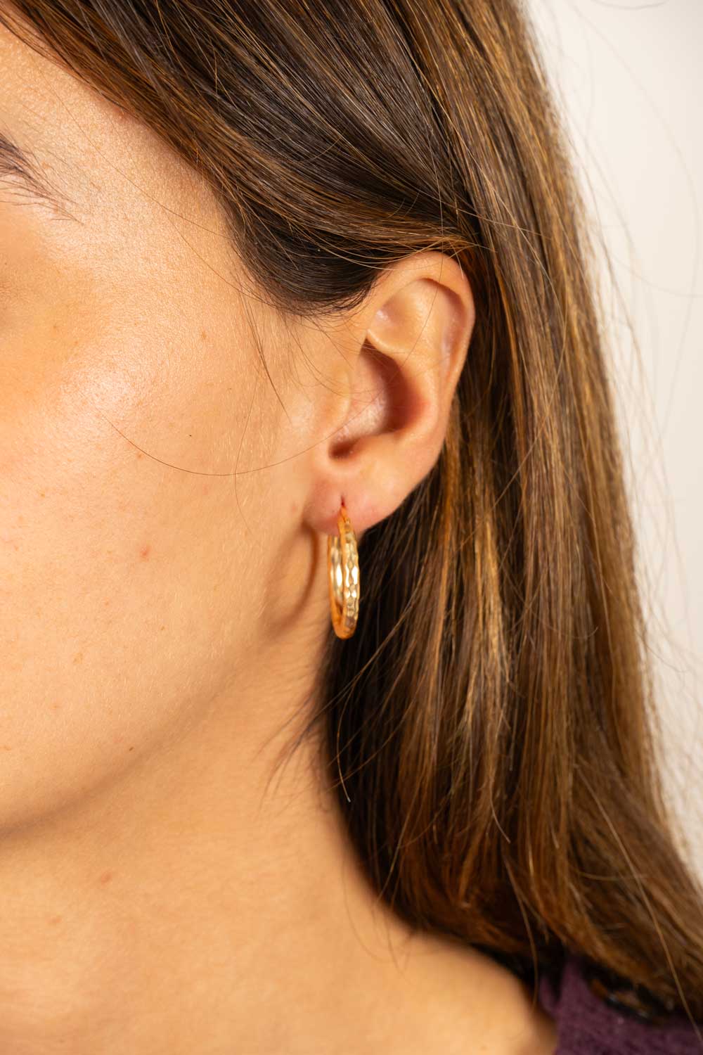 Brincos dourados com design de argolas marteladas