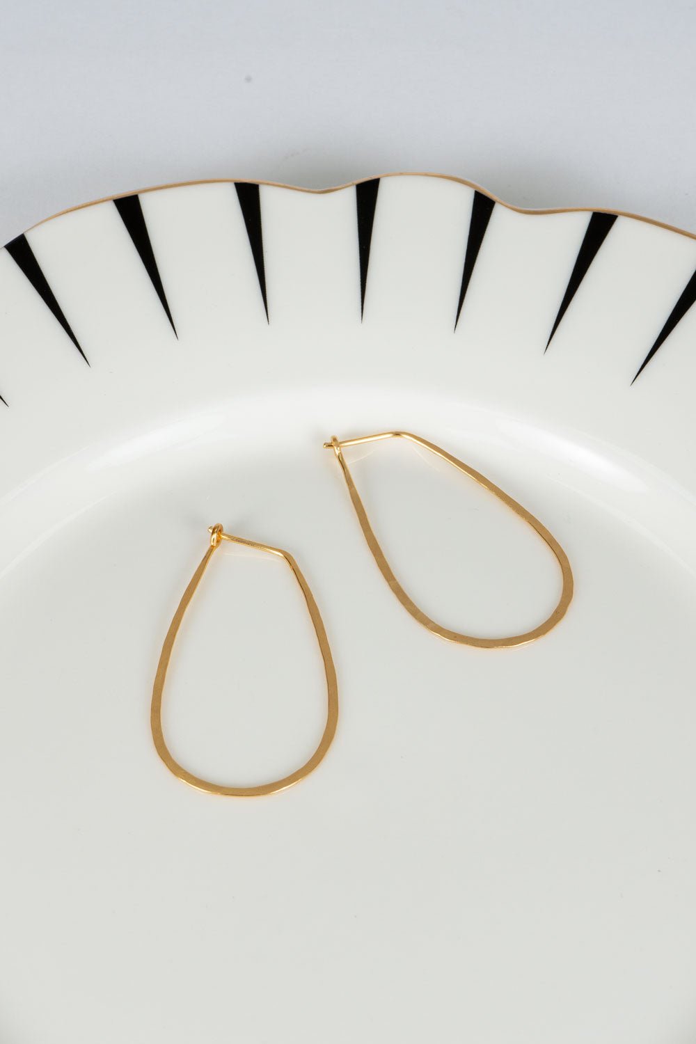 Brincos dourados com design de lágrimas