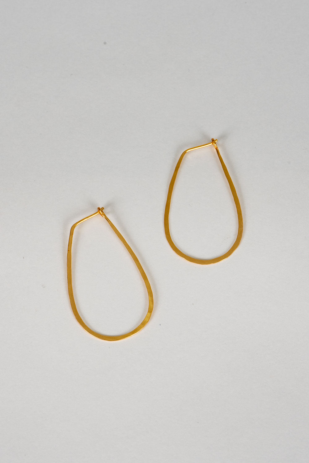 Brincos dourados com design de lágrimas