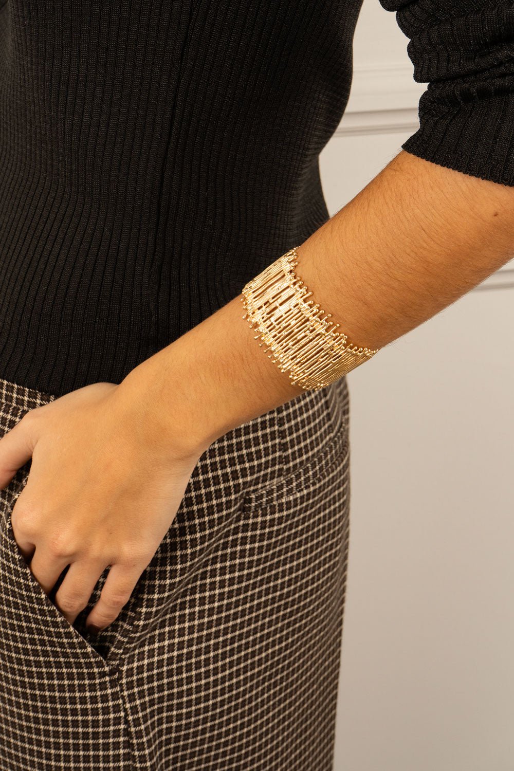 Pulseira dourada ajustável com fecho de corrente, design irregular.