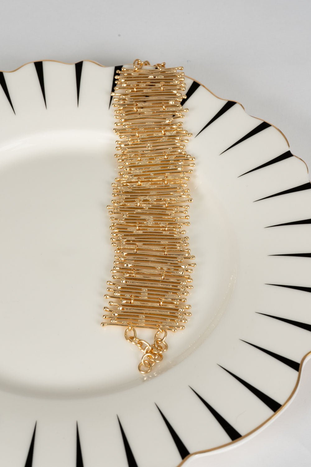 Pulseira dourada ajustável com fecho de corrente, design irregular.