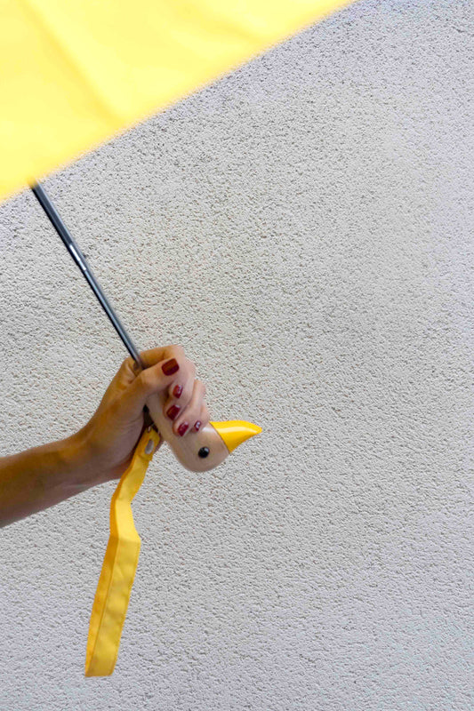 Guarda-chuva com design amarelo e pega em forma de cabeça de pato