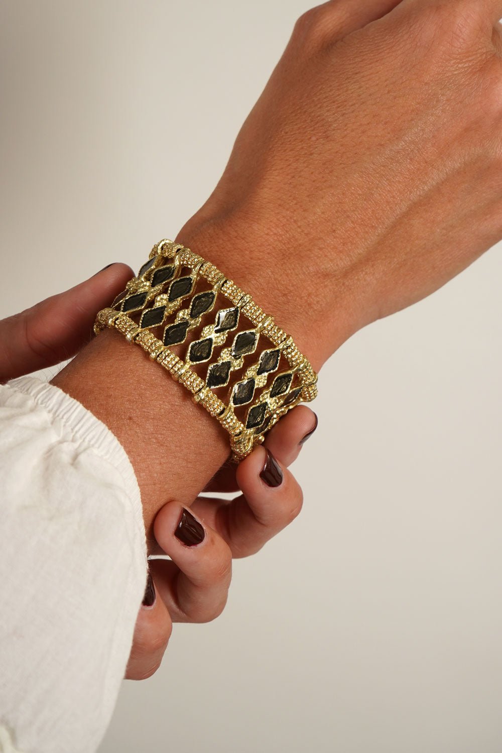 Detalle Puesto Brazalete Dorado Con Diseño De Rombos Negros Cristina Oria 