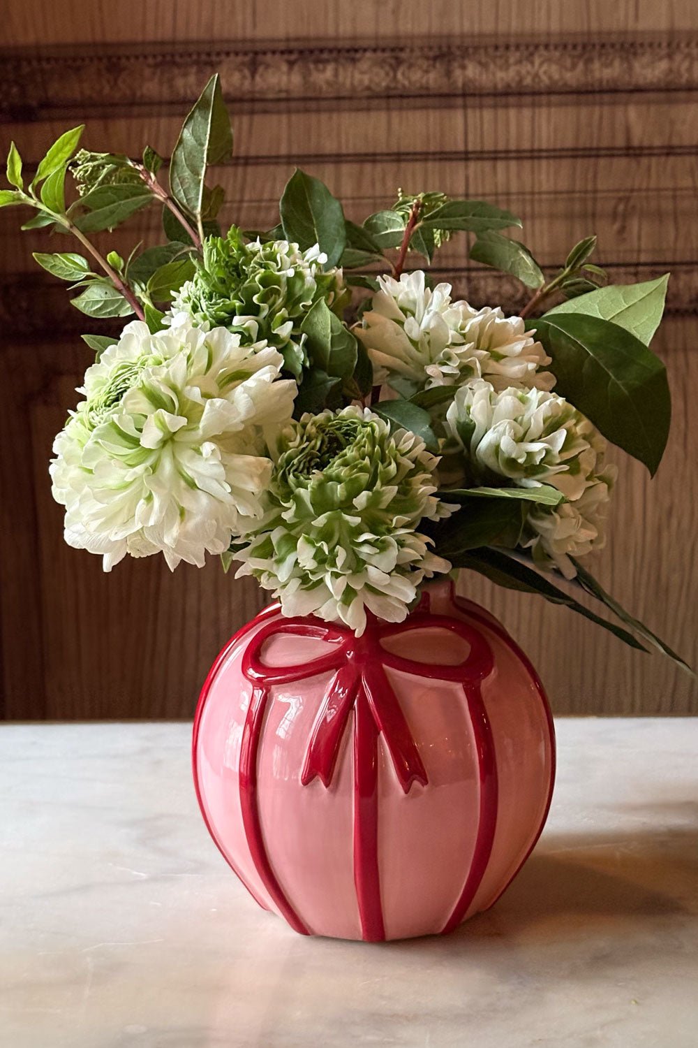 Vase en porcelaine rose avec ruban rouge