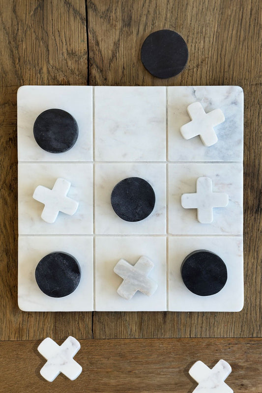 Jogo do galo em mármore branco com peças pretas e brancas