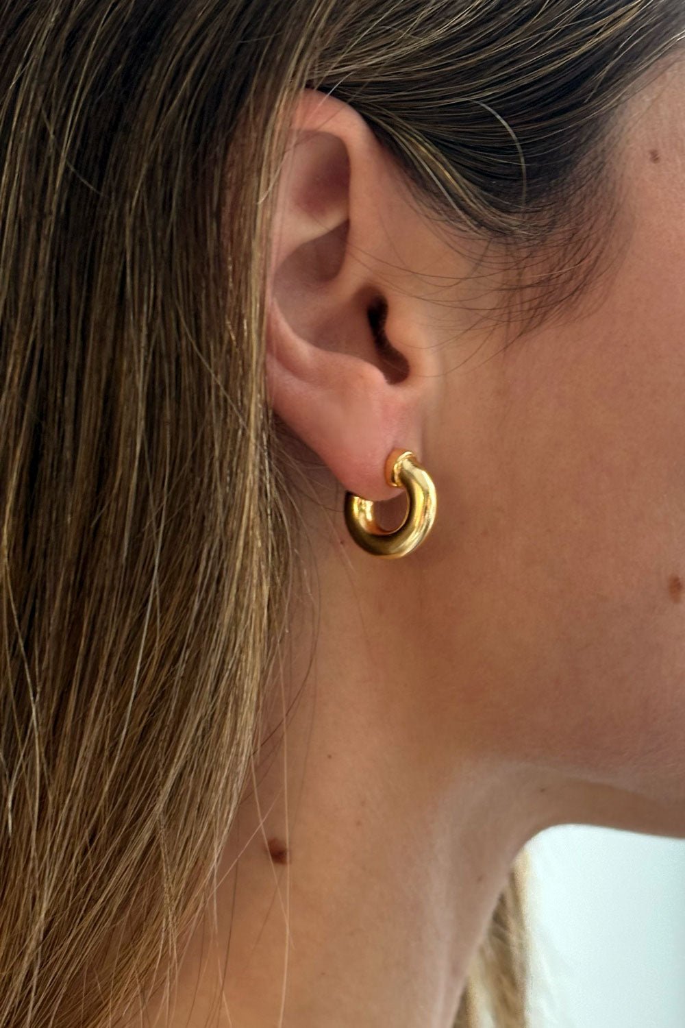 Detalle Oreja Pendientes Dorados Con Diseño De Aros Pequeños Cristina Oria 
