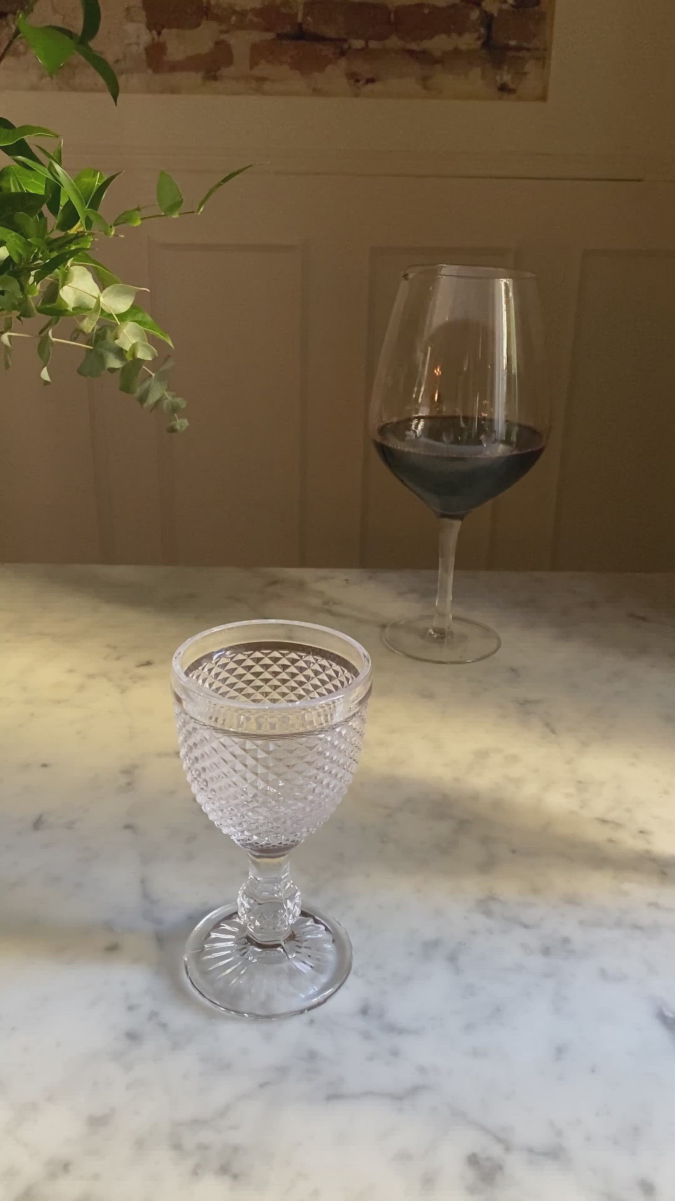 Grandes copas de vino y decantador con vino tinto sobre mesa de